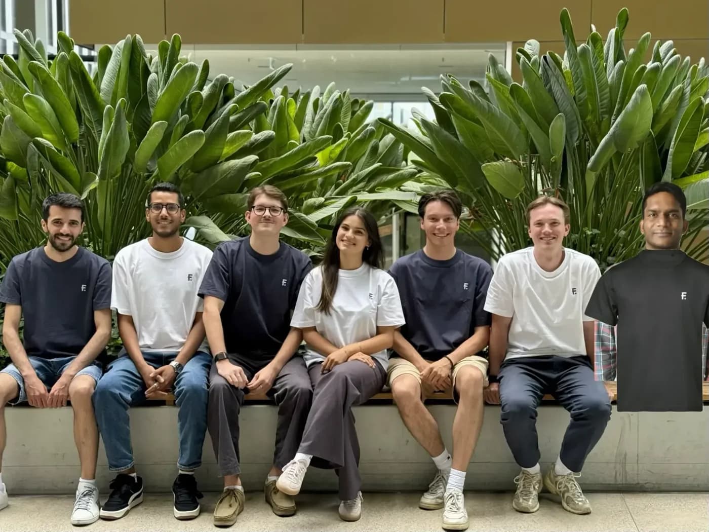 Several Fintalo team members sitting together, wearing Fintalo-branded t-shirts